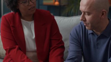 Siyahi kadın psikoloğun, danışmanlık seansı sırasında orta yaşlı beyaz adama destek verdiği bir fotoğraf.