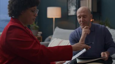 Kadın siyah danışman ile terapi seansı sırasında kağıt yırtan yetişkin bir beyaz adam.