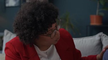 Siyahi kadın danışmanın seans sırasında depresyondaki beyaz erkek hastaya su içirirken orta boy yakın çekimi.