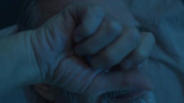 Son sınıf öğrencisinin gece geç saatte yatakta yattığını, uykuya dalmaya çalışırken gözlerini ovuşturduğunu yakından görmek.
