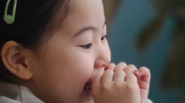 Alpha Asyalı kızın evde resim çizerken konuştuğu büyük yakın çekim, boşluğu kopyala