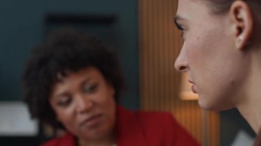 Oturum sırasında Afrikalı Amerikalı danışman ile iletişim kuran Kafkasyalı genç bir kadının odak noktası.