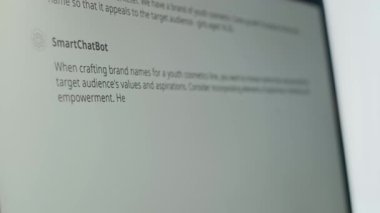 Genç siyahi kadın bilgisayar ekranında Smart Chat Bot ile etkileşime geçiyor, evde çalışırken genç kozmetik ürünleri için marka önerileri arıyor.