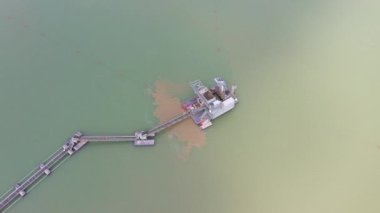 A sand dredger floating in the water at a sandpit.