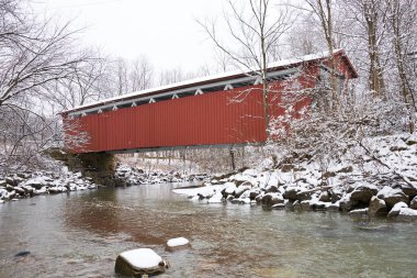 Everett yolu Cuyahoga Vadisi Ulusal Parkı 'ndaki köprüyü kapsıyordu. Köprü beyaz bir iç kısmı ile kırmızıdır. Karlı bir gün ve ormanın yakınındaki ağaçlar tüylü beyaz ağaçlarla kaplı..