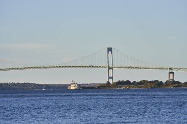 Bu küçük beyaz ışık evi Newport Rhode Island yakınlarındaki Rose Adası 'nda bulunuyor. Arka planda Claiborne Pell Newport Köprüsü var