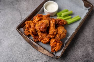 Buffalo chicken wings with celery and dip