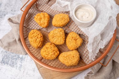 Kızarmış tavuk nuggetları soslu ve servise hazır.