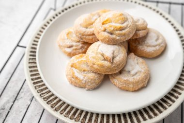 Beyaz tabakta İtalyan vişneli kurabiye. Pudra şekeri kaplı kurabiyeler.