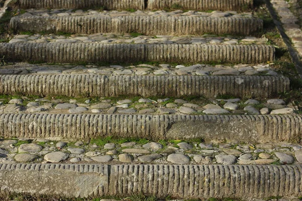 medieval staircase consisting of different stones and pieces of marble leading up
