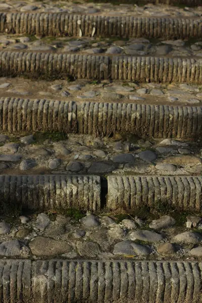 medieval staircase consisting of different stones and pieces of marble leading up