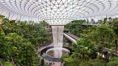 Singapur 'daki Jewel Changi Havalimanı' nda dünyanın en uzun kapalı şelalesi ve ikonik şelalesi büyüleyici bir yağmur girdabı deneyimi sunuyor.. 