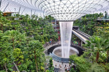 Singapur 'daki Jewel Changi Havalimanı' nda dünyanın en uzun kapalı şelalesi ve ikonik şelalesi büyüleyici bir yağmur girdabı deneyimi sunuyor.. 