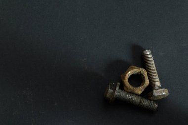 Paslı civatalar ve fındıklar karanlık arka planda boş alan