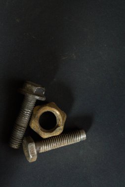 Paslı civatalar ve fındıklar karanlık arka planda boş alan