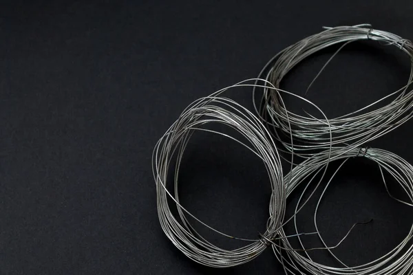 stock image coils of thin steel wire on a dark background