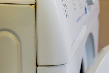 the washing machine in the bathroom is rusting