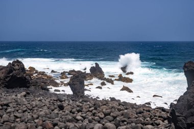 Tenesera 'nın engebeli kıyı şeridinde dalgalar kopuyor, Lanzarote, güzel bir yaz gününde.