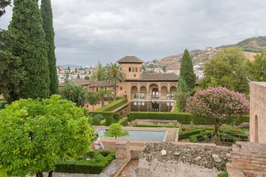 Alhambra Granada İspanya - 09 14 2021: Partal Palace veya Palacio del Partal, İspanya 'nın Granada kentindeki Alhambra Kalesi kompleksi içinde yer alan bahçeler ve su gölü etrafında saray manzarası