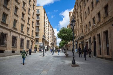 Salamanca / Spain - 05 12 2021: Exterior view of Rua Zamora or Calle Zamora in the center of Salamanca city, with buildings and people walking around, one of the busiest streets in Salamanca, Spain