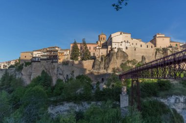 Cuenca / Spain - 05 13 2021: View at the Cuenca Hanging Houses, Casas Colgadas, typical architecture building on slope, metallic bridge, iconic architecture on Cuenca city