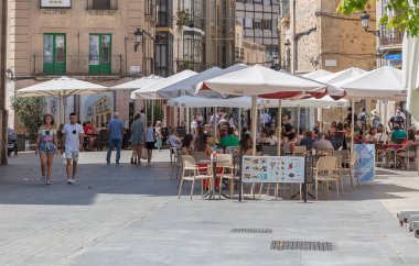 İspanya - 09 12 2021: Saint John Meydanı veya Plaza de San Juan, birkaç kişi ve aileyle, açık hava bar ve restoran terasları, sosyalleşme, yeme ve içme, İspanya şehir merkezi, Caceres