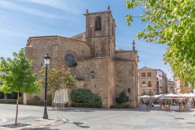 İspanya - 09: 12 2021: San Juan Bautista Meydanı 'ndaki San Juan Bautista kilisesinde, turistler şehir merkezindeki Caceres şehrinde gezip geziyorlar.