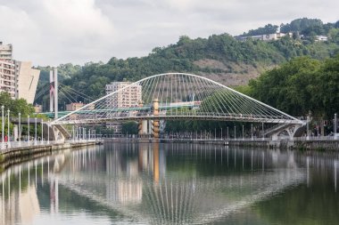 Bilbao İspanya - 07 05 2021: İkonik Zubizuri Köprüsü, Bilbao şehir merkezi, Nervion nehri ve nehir kıyıları ve binaların dış görünüşü