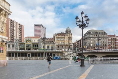 Bilbao İspanya - 07 05 2021: Arriaga Plaza, Areatzako zubia Köprüsü ve Bilbao La Concordia İstasyonu 'na arka plan olarak bakın, Bilbao şehir merkezi, Nervion nehri ve nehir kıyıları ve binaları