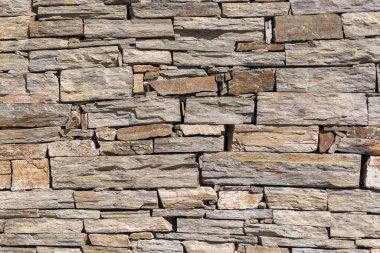 Mimari dokular, taş duvar dokusunun detaylı görünümü, inşaat için geleneksel dış duvarlarda kullanılan tipik ve geleneksel kaya taşı materyali....