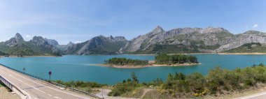 Panoramic view at the Riano Reservoir, located on Picos de Europa or Peaks of Europe, a mountain range forming part of the Cantabrian Mountains in northern Spain... clipart