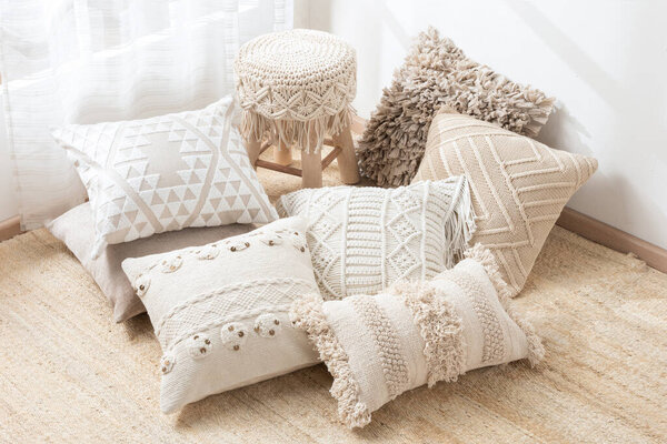 An assortment of cushions arranged on the floor of a cozy living room, providing a comfortable and inviting area