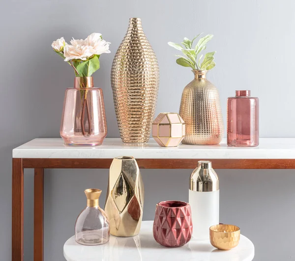 stock image A vibrant assortment of uniquely shaped and colored vases displayed on a wooden white table top