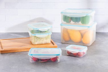 Altı verimli plastik gıda depolama sistemi ve çeşitli meyveleri olan bir mutfak tezgahı.