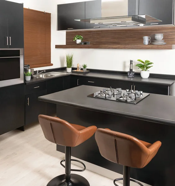 一个现代化的厨房 里面有黑色和灰色的台子和棕色的椅子 可以近距离观看 — 图库照片