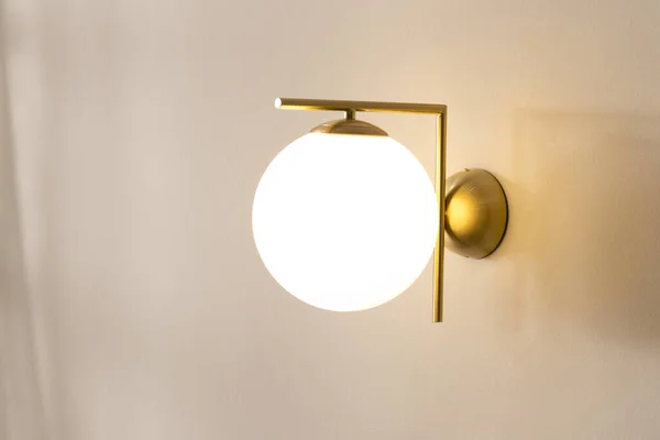 Uma Lâmpada Parede Dourada Iluminada Uma Sala Vazia Lançando Brilho — Fotografia de Stock