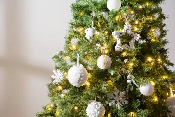 Beyaz kartopu süsleri ve ışıklarıyla süslenmiş Noel ağacı, yakın plan, fotokopi alanı, doğal ışık iç mekanı