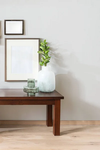 Wood Accent Bench with Plant in Glass Vases, Decoration and Wood Gallery Frames Mock-Up Mounted on White Wall in Bright Scandinavian Living Room Interior with Light Wooden Flooring.