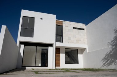 Çağdaş bir binanın dış görüntüsü beton bir cephe ve tuğla bir duvarın yanındaki pencereler.