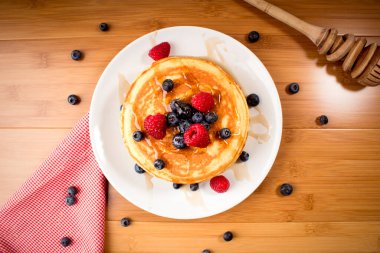 Ahududu ve yaban mersinli Amerikan gözlemeleri ahşap yüzeyde.