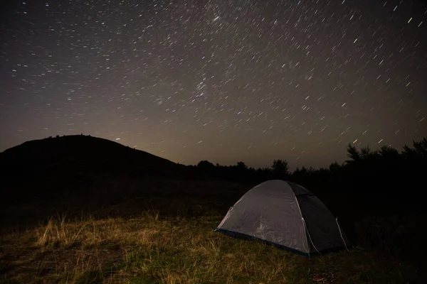 Gece gökyüzüne bakan bir tepede turist çadırı. Yüksek kalite fotoğraf