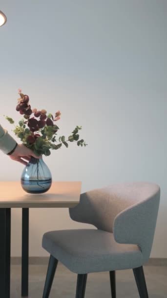 남자는 테이블에 꽃병을 배치합니다 덮개를 의자의 시리즈 고품질 Fullhd — 비디오