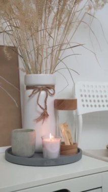 Beyaz sandalyede ve mumlarla dolu bir masada. İskandinav tarzında hafif bir iç mekan. Yüksek kaliteli FullHD görüntüler