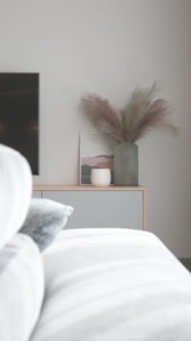 Gri bir dolapta, içinde vazolar ve İskandinav tarzı bir tablo olan büyük bir televizyonun yakın plan çekimi. Yüksek kalite 4k görüntü