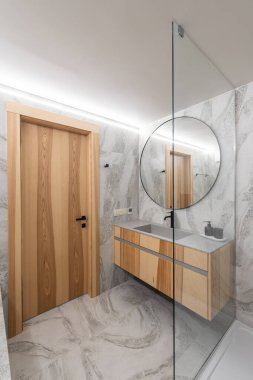 Explore this sleek modern bathroom with a stunning wooden door, stylish sink, and elegant glass shower clipart