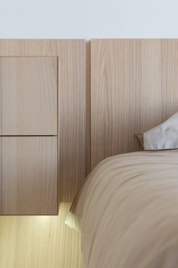 Doğal ahşap kaplamalarla ve sakinleştirici nötr tonlarla tasarlanmış gösterişli ve modern bir yatak odası.