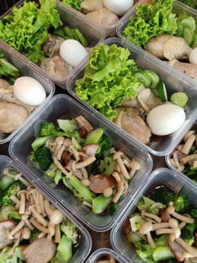 Taze sebze salatasını mantarlı ve tavuklu plastik kabın içine koy.