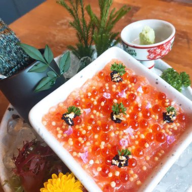 Ahşap bir masada kırmızı havyarlı somon yumurtası.