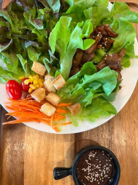 Beyaz tabakta salata ve susam tohumu, Tayland.