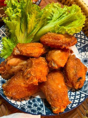 Kızarmış tavuk kanadı ve tabakta marul yaprakları, Tayland.